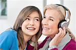 Woman with her granddaughter listening to headphones