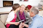 Girl kissing her grandmother with her grandfather sitting beside them