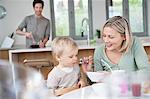 Woman feeding breakfast to her son