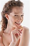 Portrait of a woman holding a cod liver oil capsule and smiling