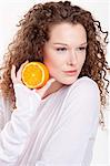 Gros plan d'une femme tenant une moitié d'orange