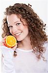 Portrait of a woman holding a half of an orange