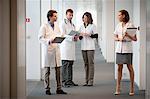 Four doctors standing at the corridor of a hospital