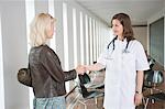 Female doctor shaking hand with a woman