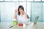 Businesswoman holding a cherry tomato and smiling