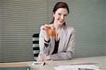 Female real estate agent holding house keys in an office