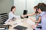 Female real estate agent shaking hands with a couple