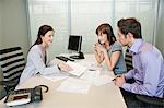 Female real estate agent showing a brochure to a couple