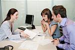 Female real estate agent showing a brochure to a couple