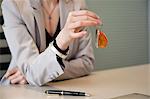 Female real estate agent holding house keys in an office