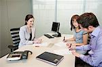 Couple signing agreement form in a real estate agent's office