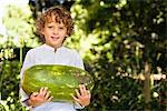 Portrait of a smiling boy holding a watermelon