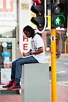 Man using a laptop near traffic light