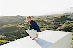 Jeune homme regardant la vue depuis la terrasse d'une maison