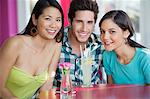 Portrait d'un homme et femmes avec jus de lime sur la table dans un restaurant