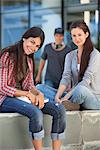 Portrait of two female friends sitting in a campus