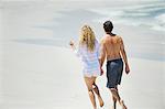 Rückansicht eines Paares zu Fuß am Strand