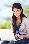 Portrait of a woman using a laptop and smiling