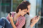 Young woman showing her message to her friend