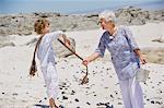 Senior woman with her grandson collecting shell on the beach