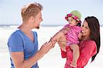 Couple enjoying on the beach with their daughter