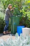 Femme regardant dans le bac de recyclage