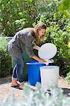 Woman throwing papers in garbage bin