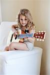 Portrait of a cute little girl playing a guitar