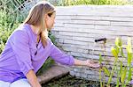 Schöne junge Frau mit der Hand unter fließenden Wasser