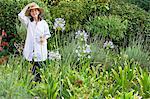 Portrait d'une femme senior tenant des fleurs dans un jardin