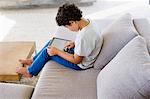 Side profile of a boy using a digital tablet