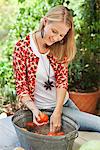 Smiling woman washing tomatoes