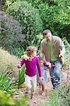 Père de deux enfants marchant dans un jardin