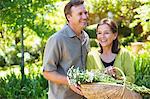 Man with his mother holding basket of flowers outdoors