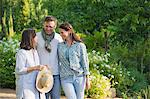 Happy mature couple standing with their mother in a garden