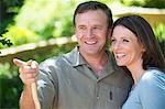 Smiling man showing something to his wife outdoors