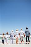 Vue arrière d'une famille en regardant la vue sur la mer de la plage