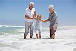 Granddaughter enjoying with grandparents on beach