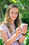 Smiling little girl text messaging using a mobile phone