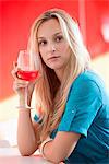 Young woman having red wine and thinking in a bar