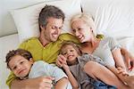 Couple with their children relaxing in bed