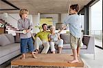 Boys playing with their parents sitting on a couch