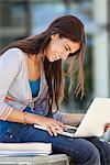 Close-up of a smiling woman using a laptop