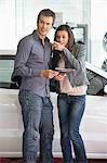 Couple buying a car in showroom