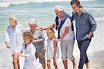 Famille multigénérationnelle marchant sur la plage