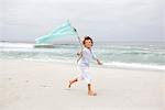 Junge ausführt, während mit der Flagge am Strand