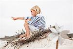 Mise au point sélective d'une jeune fille assise sur le sable