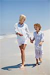 Woman walking on the beach with her son