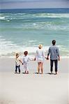 Couple with their children standing on the beach