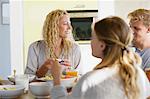 Fille avec ses parents à une table à manger le petit déjeuner